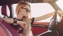 Картинка: Девушка в солнцезащитных очках сидит за рулем авто.