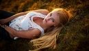 Image: Girl in white lying on the grass with a passionate glance.