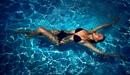 Картинка: Девушка плавает в бассейне на спине.