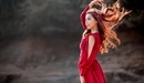 Картинка: У азиатки в красном платье волосы развиваются на ветру.