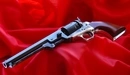 Картинка: Револьвер лежит на фоне красной ткани.