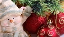 Картинка: Фигурка снеговика с новогодними шарами у ёлочки.