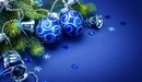 Картинка: Синие ёлочные шары с серебряными колокольчиками лежат в ветках ели