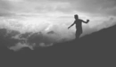 Картинка: Мужчина идёт по склону горы держа равновесие руками