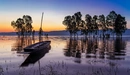 Картинка: Лодка на озерной глади на закате дня.
