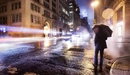 Картинка: Мужчина под зонтом идёт по улице.