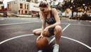 Картинка: Девушка позирует с баскетбольным мячом на корте