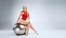 Картинка: Блондинка с красивой фигурой сидит на фитнес мяче в красном купальнике