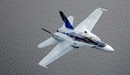 Картинка: Истребитель CF-18 Hornet летит над поверхностью воды.