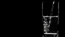 Картинка: В стакан на чёрном фоне наливают чистую прозрачную воду