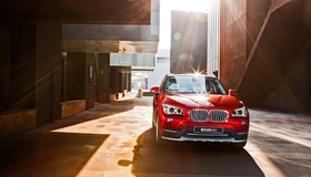 Картинка: BMW, X1, яркий, красный, солнечные лучи, здания