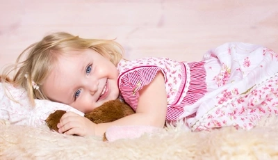 Картинка: Девочка, глаза, волосы, лежит, плед, подушка, игушка, платье, улыбка, настроение