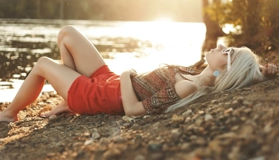 Картинка: Девушка, блондинка, лежит, камни, озеро, очки, закат