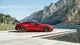Картинка: Красный автомобиль Aston Martin на фоне озера и гор