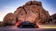 Картинка: Nissan GTR стоит на дороге возле большой скалы