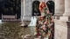 Картинка: Девушка в красивом цветочном платье позирует рядом с каменной черепахой