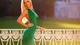 Картинка: Стройная блондинка в длинном зелёном платье с глубоким декольте стоит держась за ограждение