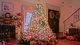 Image: Beautiful and elegant Christmas tree with gifts stands at home by the fireplace