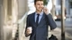 Картинка: Стильный мужчина в костюме держит стаканчик кофе в руке и разговаривает по телефону