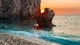 Картинка: Солнце садится за скалами, с видом на море
