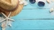 Картинка: Плетёная шляпа с очками лежат среди ракушек