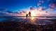 Картинка: Папа с сыном прогуливаются по берегу моря на закате солнца