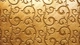 Image: Golden background with a pattern of swirls