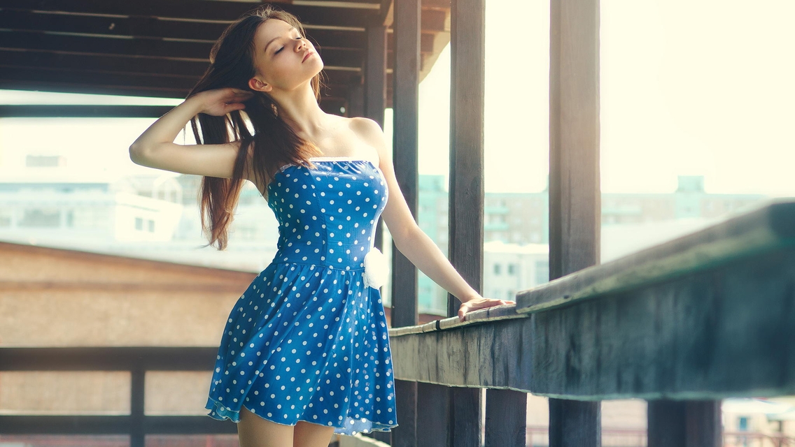 Image: Brunette, girl, hair, blue dress, polka dots, railings