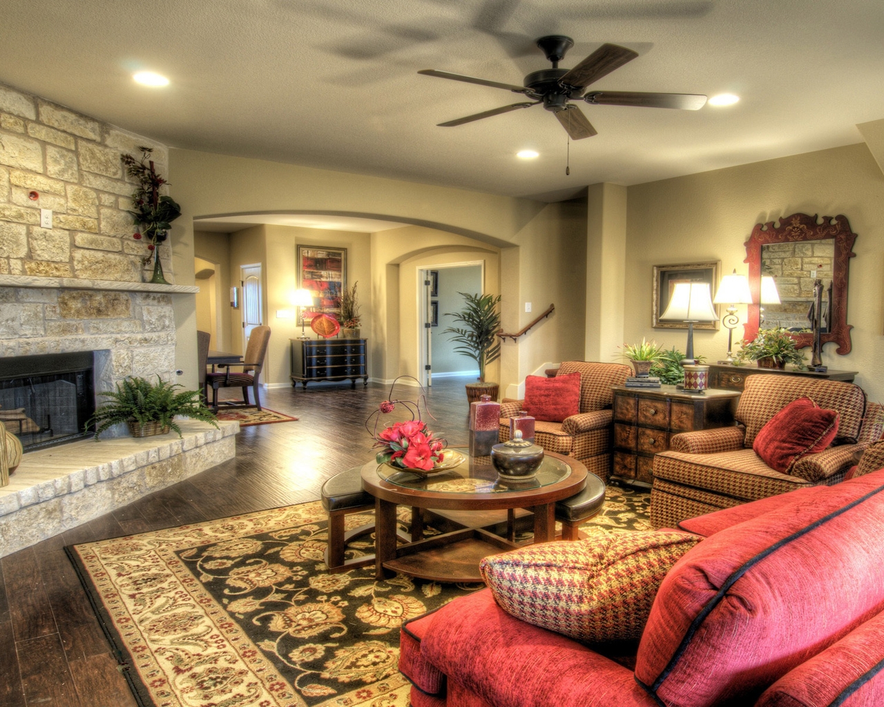 Image: Living room, fireplace, stone, floor, carpet, table, plants, flowers, mirror, vase, chair, sofa, pillows, dresser, lamp
