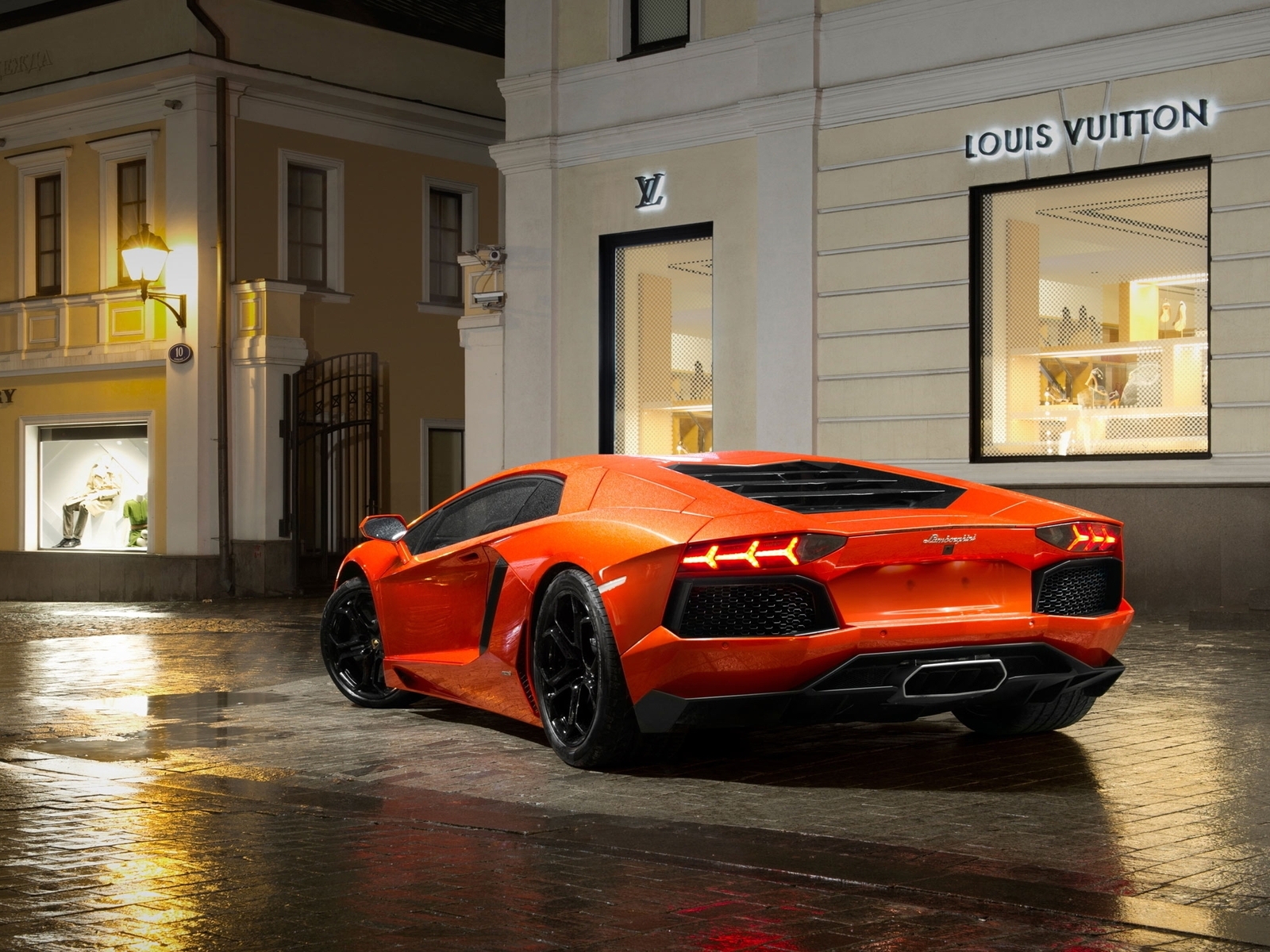 Картинка: Суперкар, оранжевый, Lamborghini, Aventador, lp700 4, roadster, тротуар, дорога, мокрая, здания, фонари, магазины, ночь