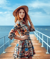 Image: Girl, blonde hair, hat, dress, pier, water, sky, clouds