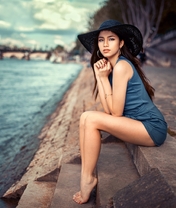 Image: Girl, brunette, sitting, legs, hat, dress, blue, waterfront, water, river, steps, barefoot