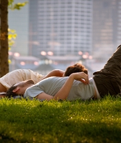 Image: Guy, girl, couple, lying, grass, lawn, leisure, foliage, city, buildings, houses, street