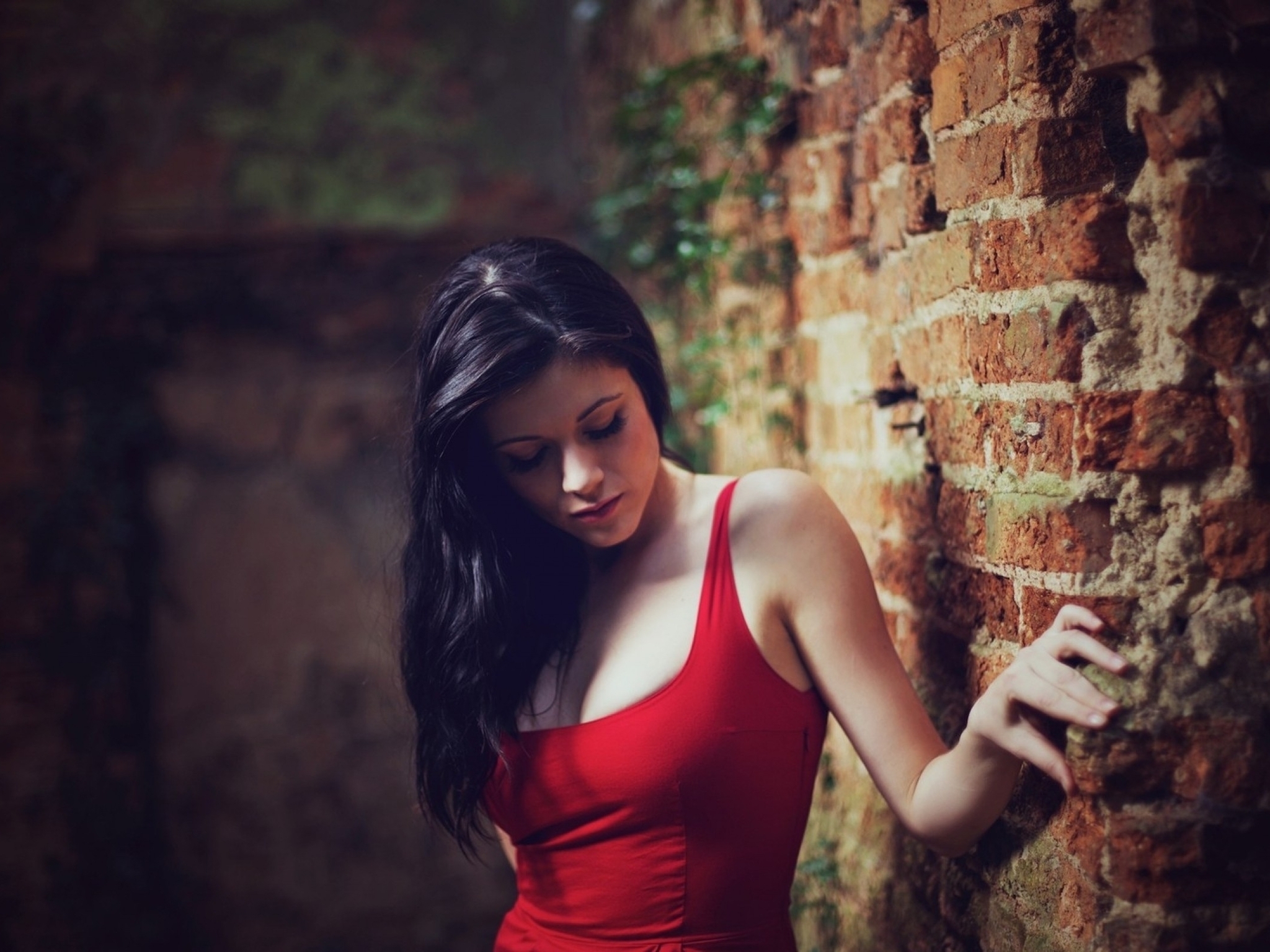 Картинка: Девушка, чёрные волосы, кирпичная стена, упирается, в красном