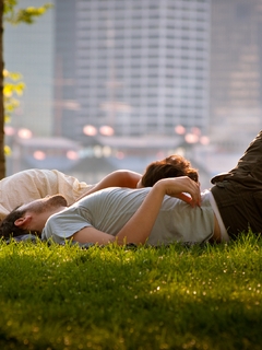 Image: Guy, girl, couple, lying, grass, lawn, leisure, foliage, city, buildings, houses, street