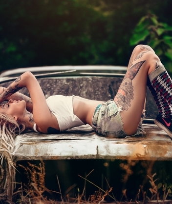 Image: Girl, blonde, tattoo, posing, lying, car, old, rusty, photo shoot, nature