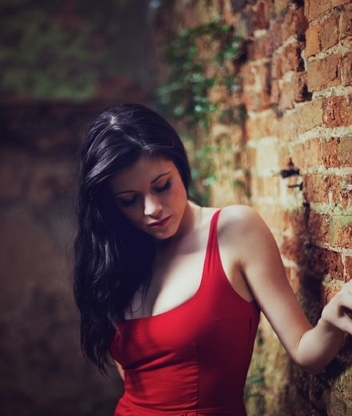 Image: Girl, black hair, brick wall, rests, red