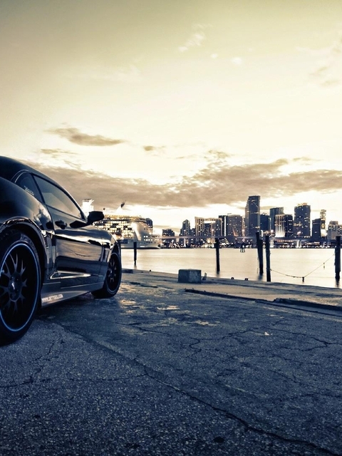 Картинка: Chevrolet Camaro, тёмный, стоп огни, город, высотки, здания, река, набережная, серое небо