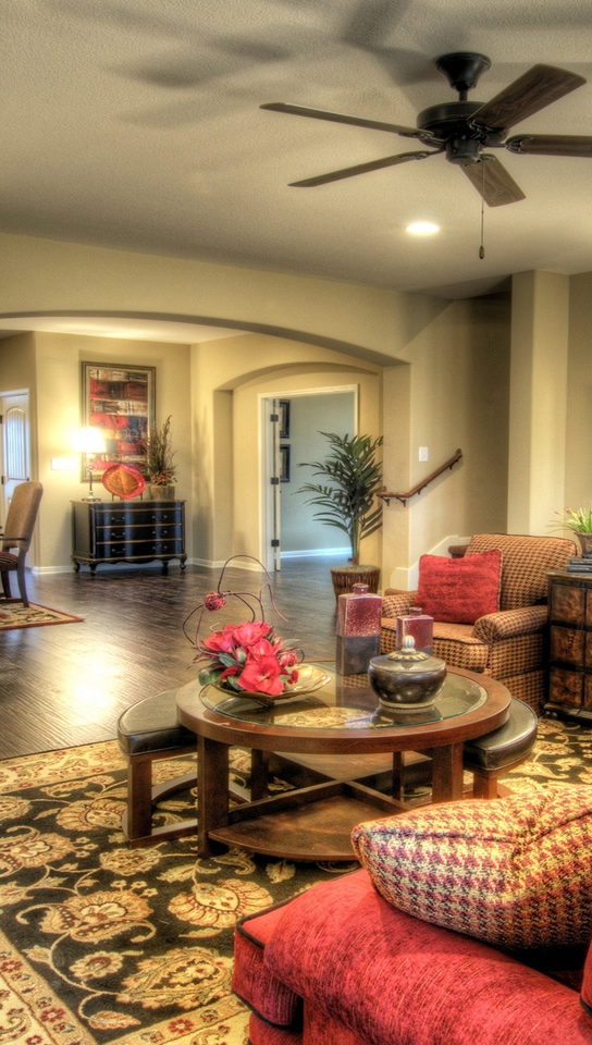 Image: Living room, fireplace, stone, floor, carpet, table, plants, flowers, mirror, vase, chair, sofa, pillows, dresser, lamp