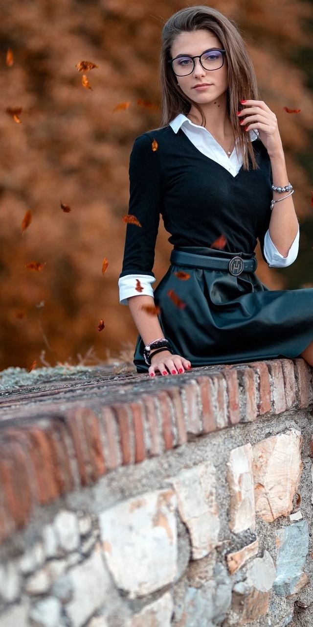 Image: Girl, brunette, glasses, skirt, leather sits, heels, leaves, autumn, brickwork